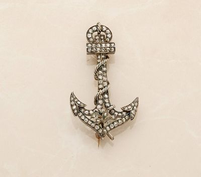 an anchor shaped broochle with diamonds on a white background