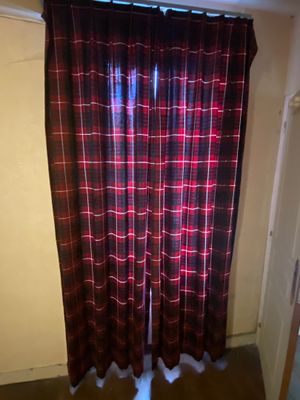 a red and black curtain in a room with wood floors
