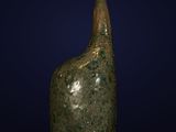 a green glass bottle with a long neck on a blue background