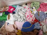 a white bag full of clothes and clothes on the floor
