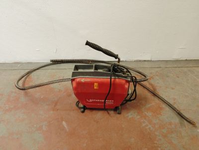 une petite machine rouge munie d'un cordon