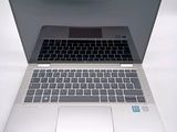 a silver laptop with a black keyboard on a white surface