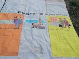 une couverture avec des images de personnes, posée sur l'herbe