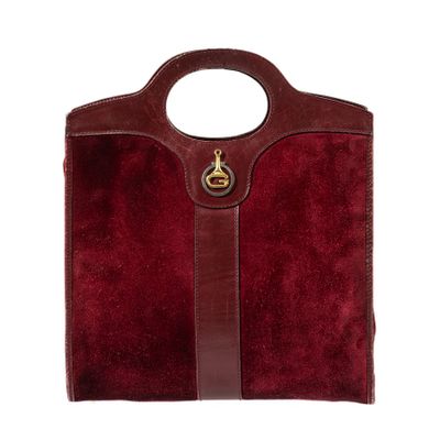 a red sued handbag with a brown leather handle