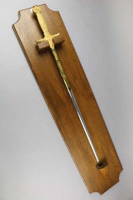 a wooden plaque with a sword hanging on the wall