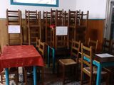 tables and chairs in a room with a red table cloth on the table