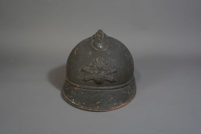 un petit casque en métal orné d'un oiseau