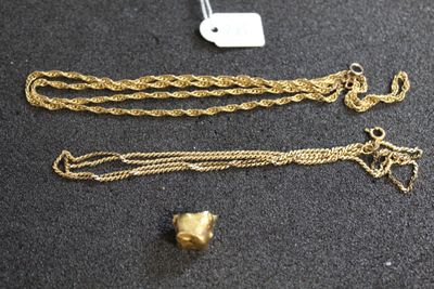 un gros plan sur un collier en or et une chaîne posés sur une table