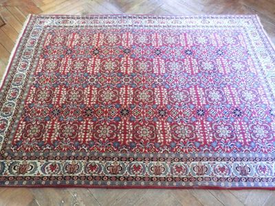 un tapis rouge posé sur un parquet dans une pièce