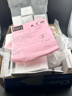 une boîte contenant un t-shirt rose et d'autres articles