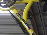 a yellow bike with a black seat and a yellow handlebar
