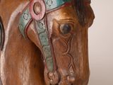 a wooden statue of a horse with a bridle on it ' s head