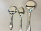three spoons and a spoon rest on a white surface