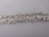 a close up of a silver chain bracelet on a table