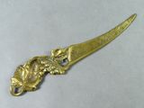 a close up of a gold plated knife on a white surface