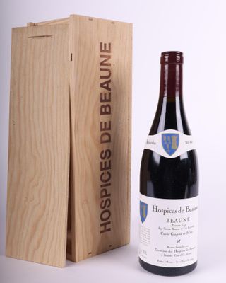 a bottle of red wine in front of a wooden box