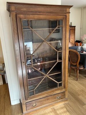 une armoire en bois avec une porte vitrée, au milieu de la pièce