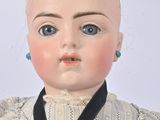 a close up of a doll with a black tie around it ' s neck