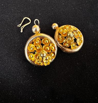 boucles d'oreilles plaquées or ornées de perles dorées sur fond noir