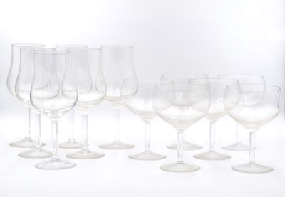 plusieurs verres à vin vides sont alignés sur une surface blanche