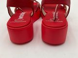 a pair of red sandals on a white surface