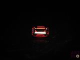 a close up of a red light shining on a black surface