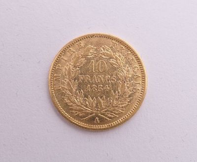 gros plan d'une pièce d'or sur une surface blanche