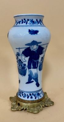 a blue and white vase with a man on it