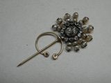 une broche ornée de perles et d'une épingle