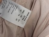 a label on the back of a beige jacket