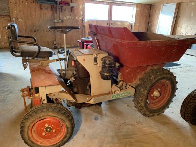 a small tractor with a red seat in a garage