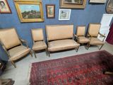 five chairs and a rug in a room with pictures on the wall