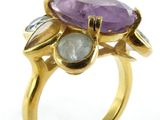 an image of a close up of a gold ring with a purple stone