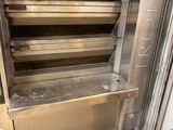 un four en métal posé dans un coin d'une pièce