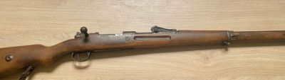 Un vieux fusil est posé sur une table en bois.