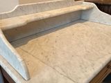 a marble top desk in a room with a mirror on the wall