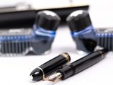 two fountain pens sitting next to each other on a table