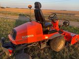 a red lawn mower sitting in the middle of a field