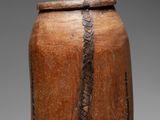 an image of a large wooden jar with a snake skin handle