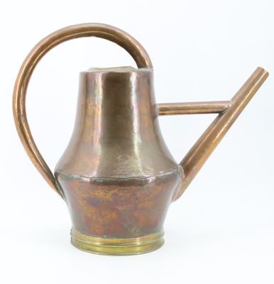 an old copper watering can with a wooden handle on a white background