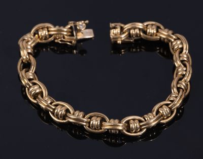 a gold chain bracelet with a clasp on a black surface