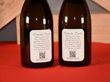 two bottles of wine sitting on a red table