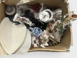 a cardboard box filled with assorted items on a white surface