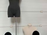 three mannequins sitting on a table next to a pair of black shoes