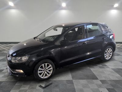 the black volkswagen polo is parked in a room with a checkered floor