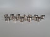 six different sizes of stainless steel rings on a white surface