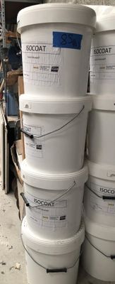 several white buckets stacked on top of each other in a warehouse