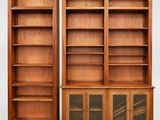 deux bibliothèques en bois avec des portes vitrées et des étagères de chaque côté