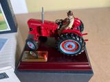 a red toy tractor with a man on it