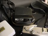 a camera, a bag, and a cell phone sitting on a table